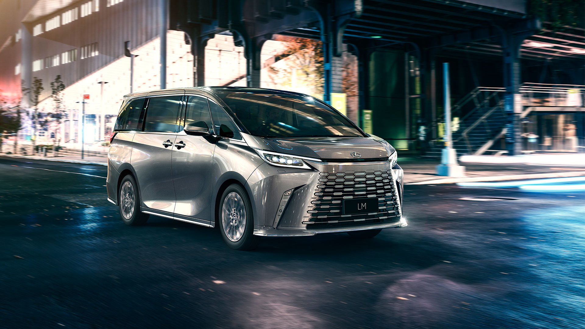 Front on view of a silver LM driving at nighttime.