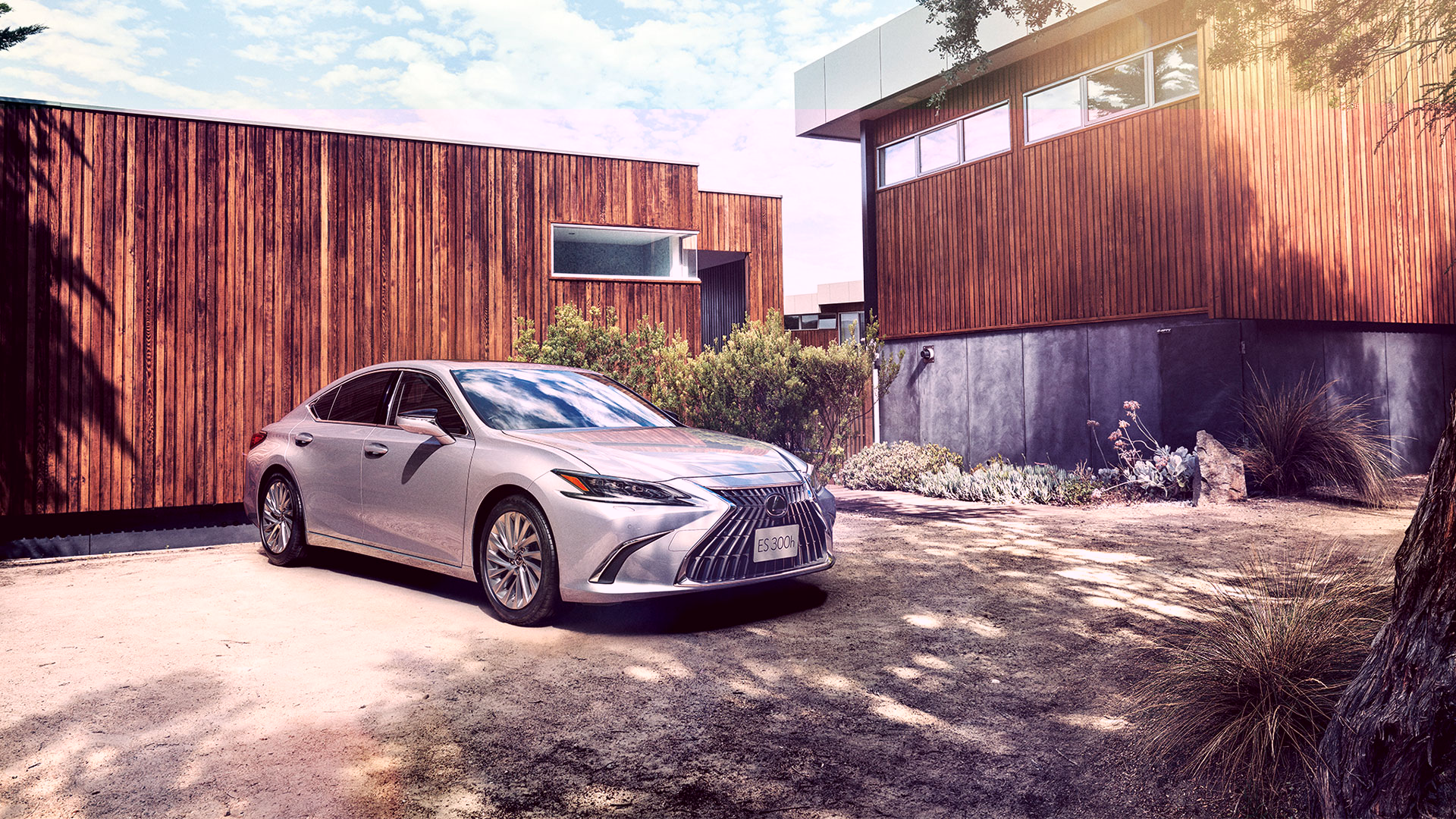 A stationary ES shown from an angle, with a modern wooden house behind it.