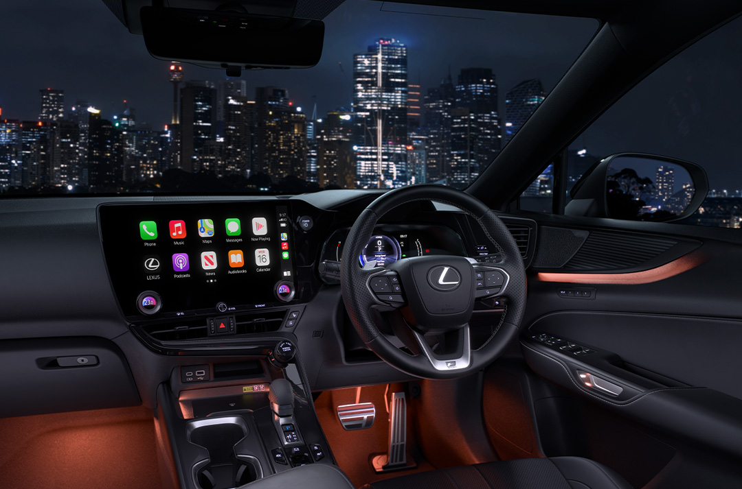 Red lit interior of the Lexus NX 350h with a city skyline.