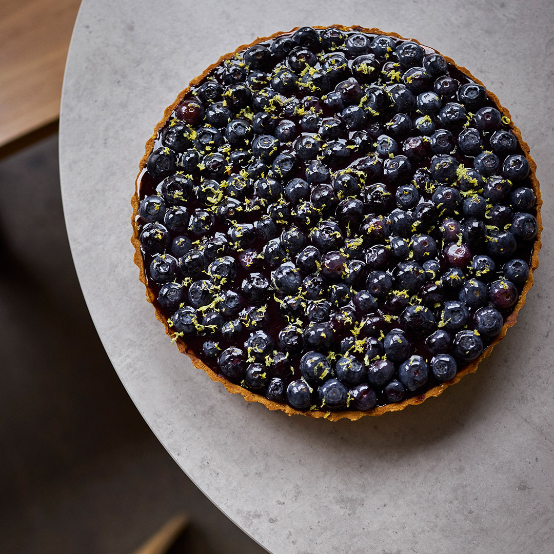 A marble benchtop with a blueberry tart