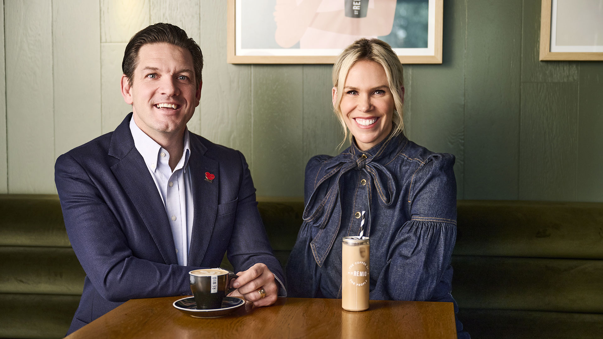 Trent Knox and Julia Tink seated at a table, smiling, with coffee cups in a café setting