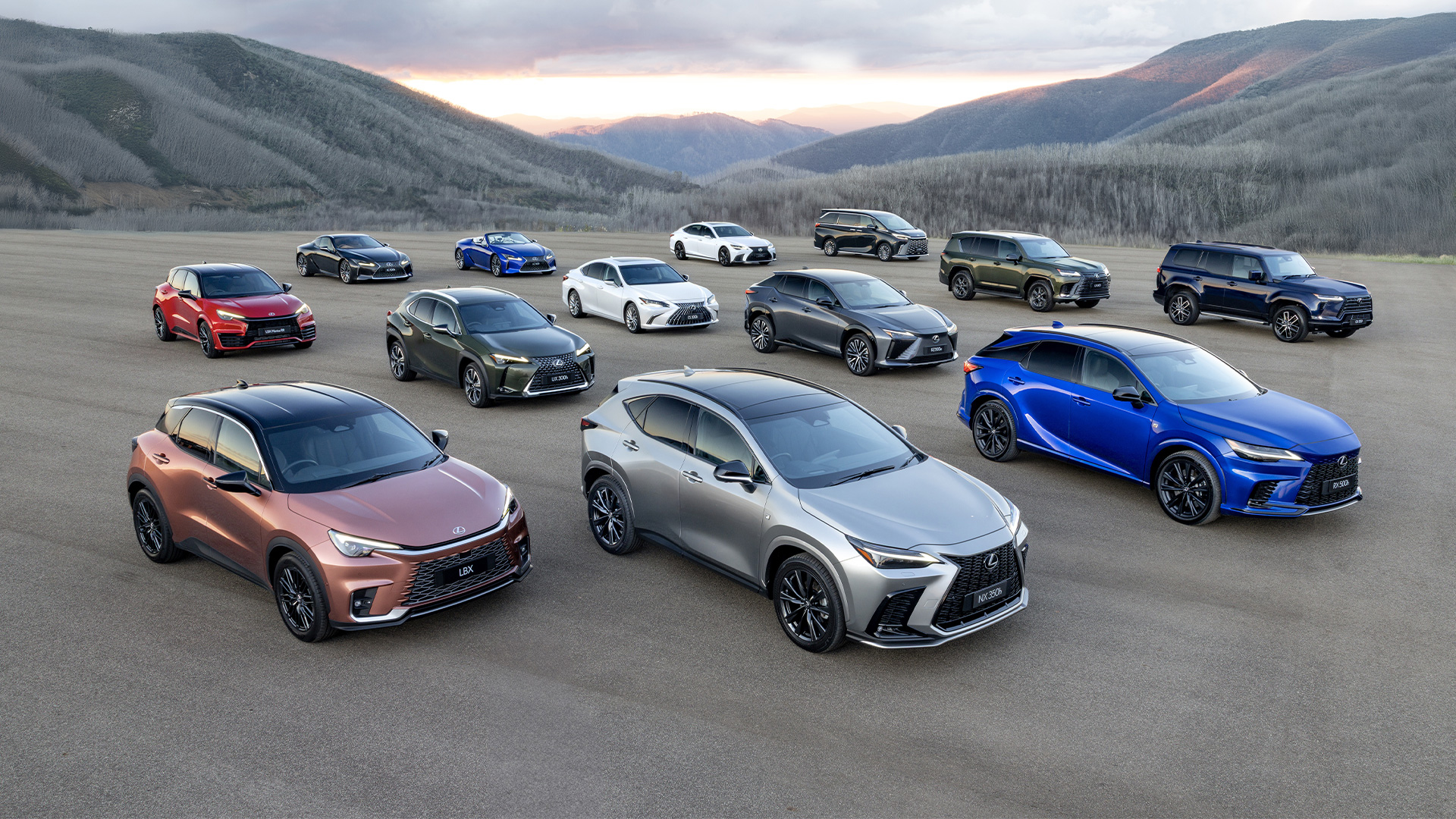 Lexus vehicle lineup including SUVs and sedans displayed on open landscape with mountain backdrop